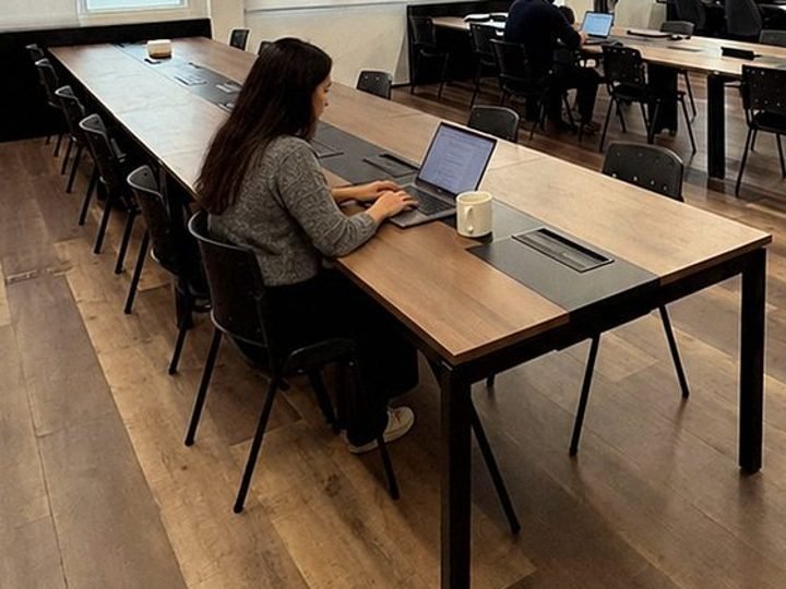 Pessoa trabalhando no notebook na bancada da área compartilhada